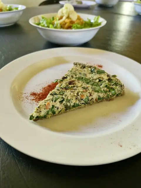 Porción de tarta de verduras con ensalada
